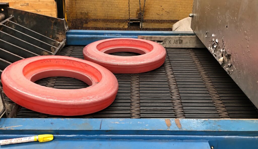 Hot forged rings leaving the press on a Transcon wire mesh belt conveyor